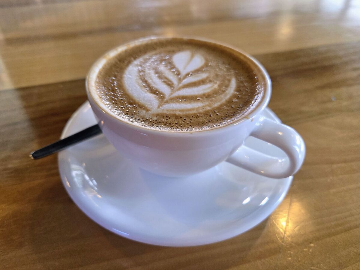 A cup of coffee with latte art on a café table
